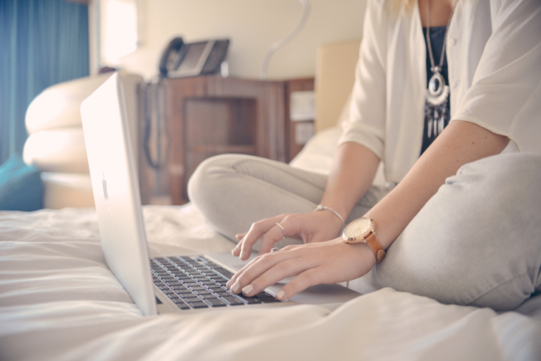 woman sitting on a bed and bloging